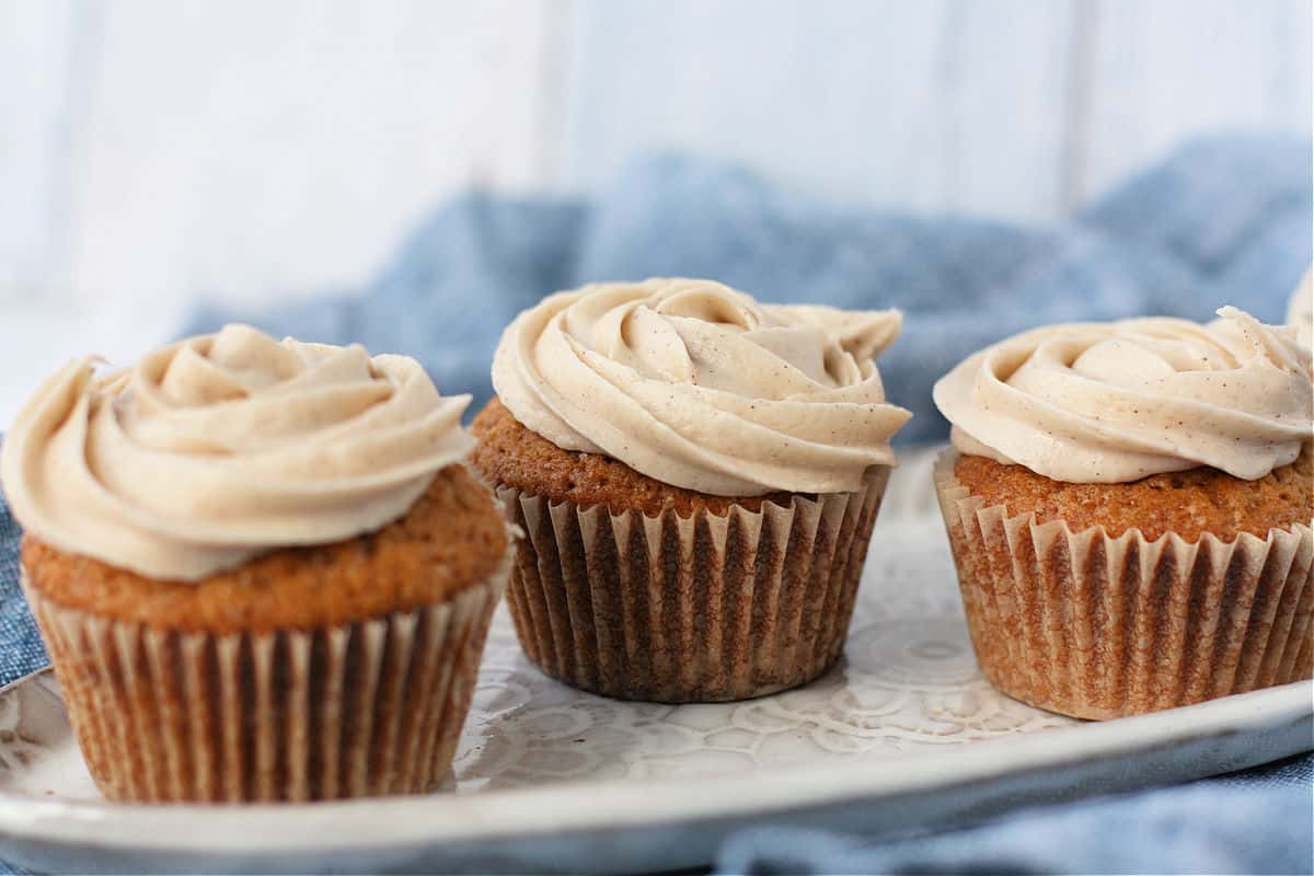 cinnamon cupcakes with frosting on a ceramic tray