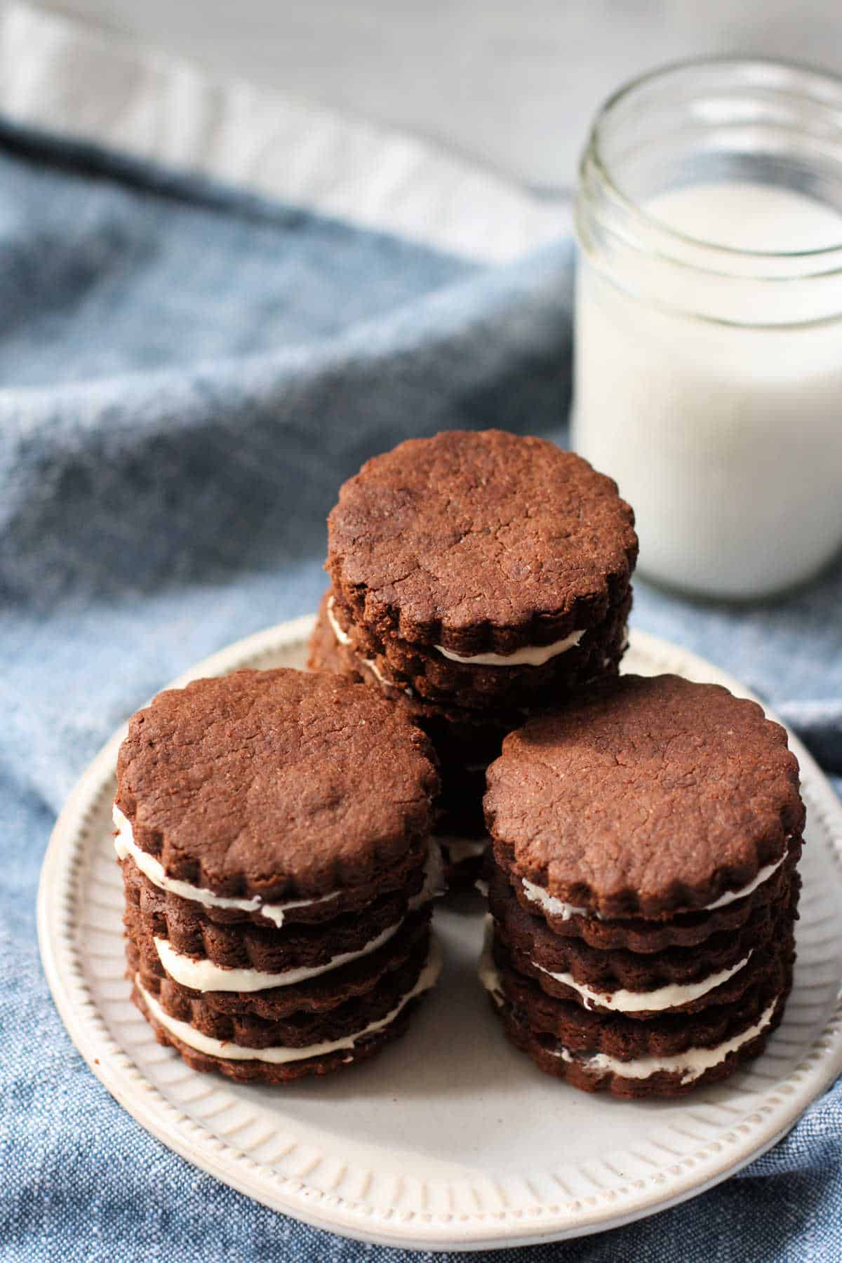 gluten free vegan chocolate cream filled cookies on a white plate