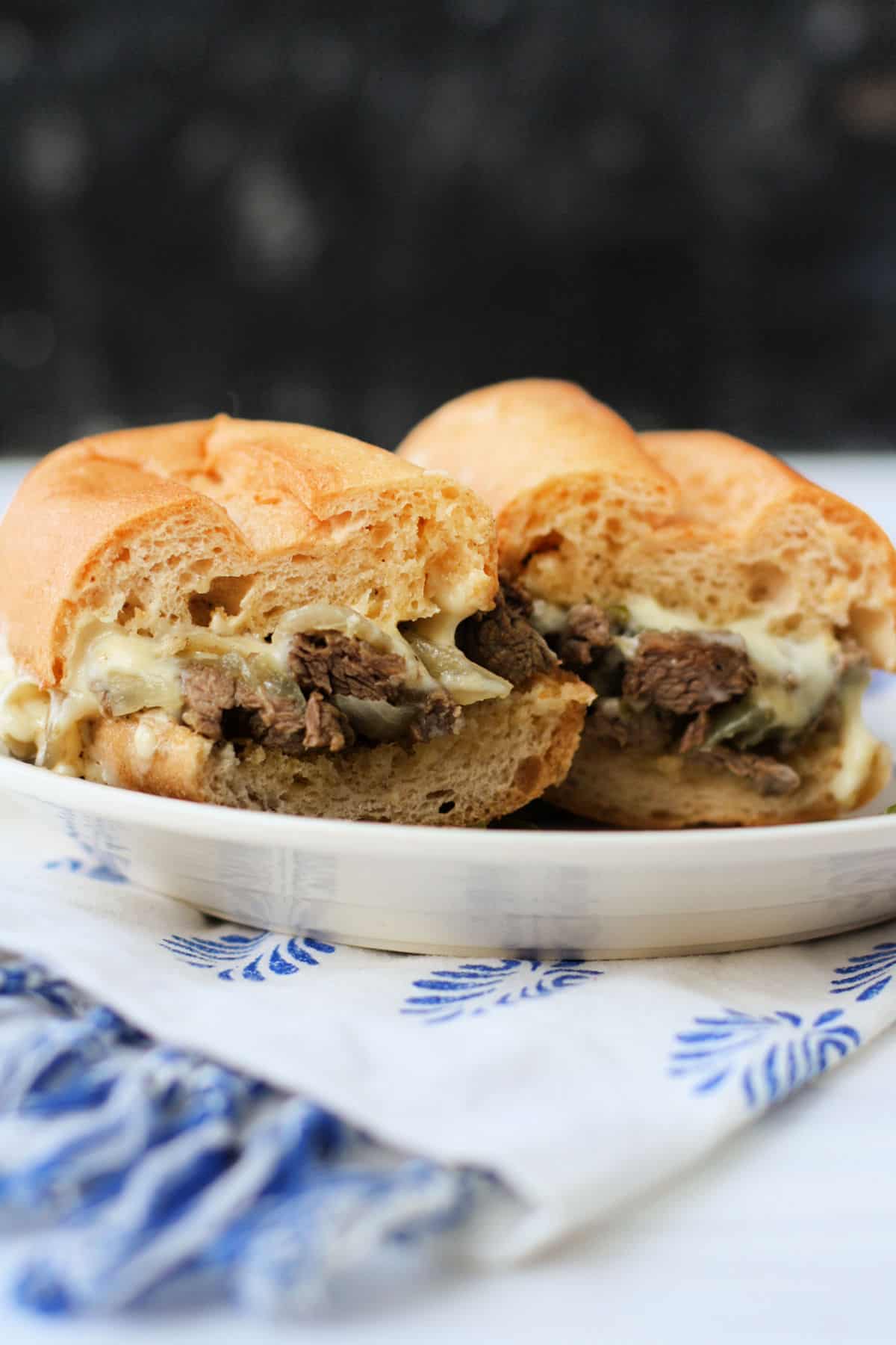 philly cheesesteak sandwiches on a white plate