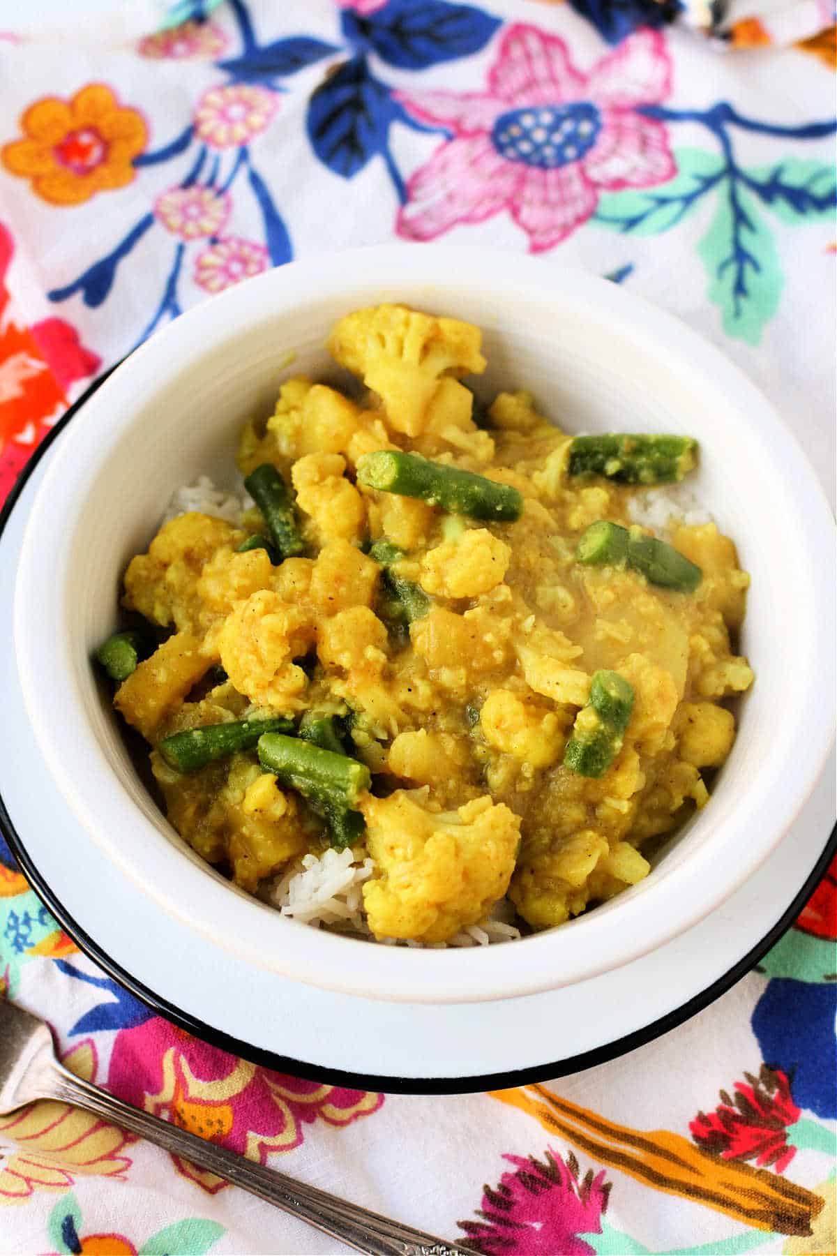 curry vegano de coliflor y patata en un bol blanco