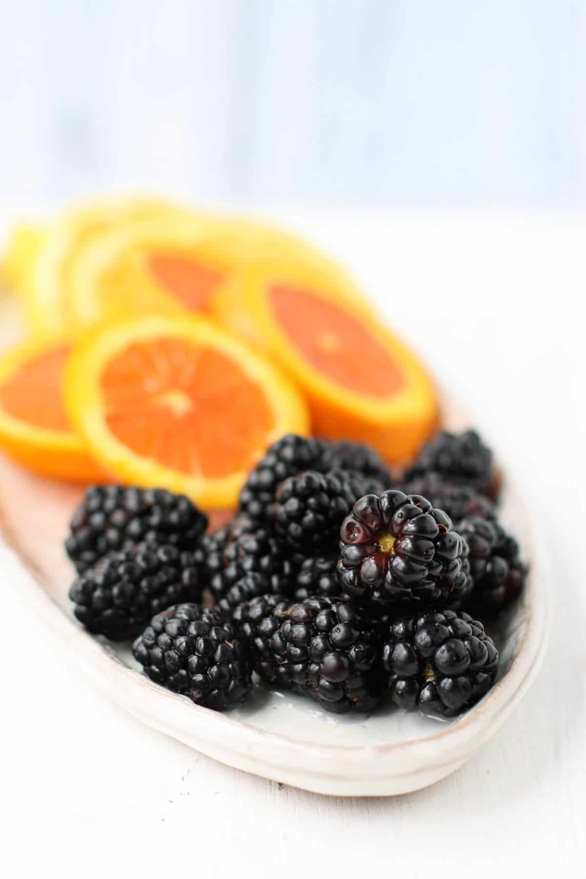 oranges and blackberries on a plate
