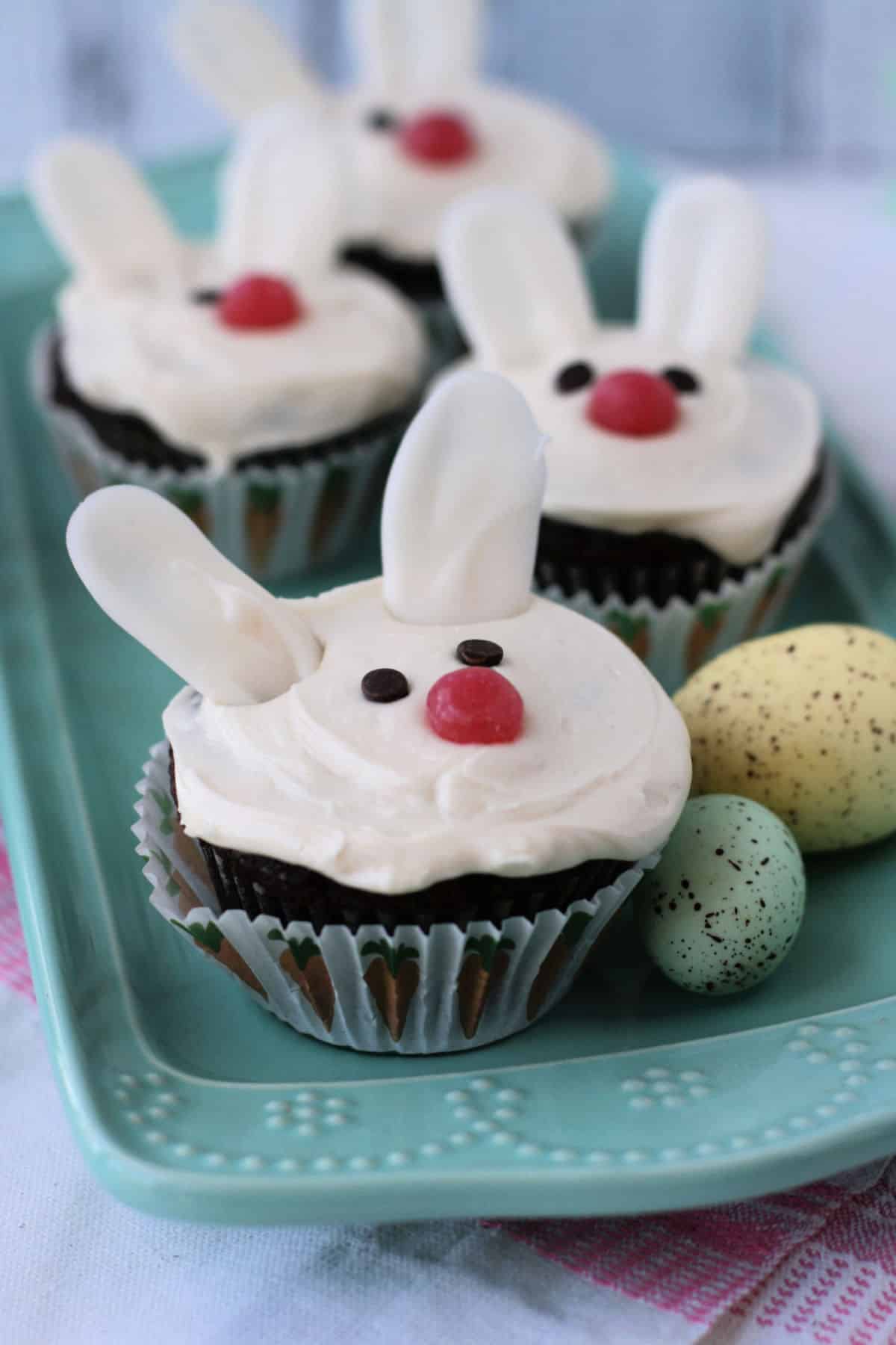 vegan easter bunny cupcakes on a turquoise tray