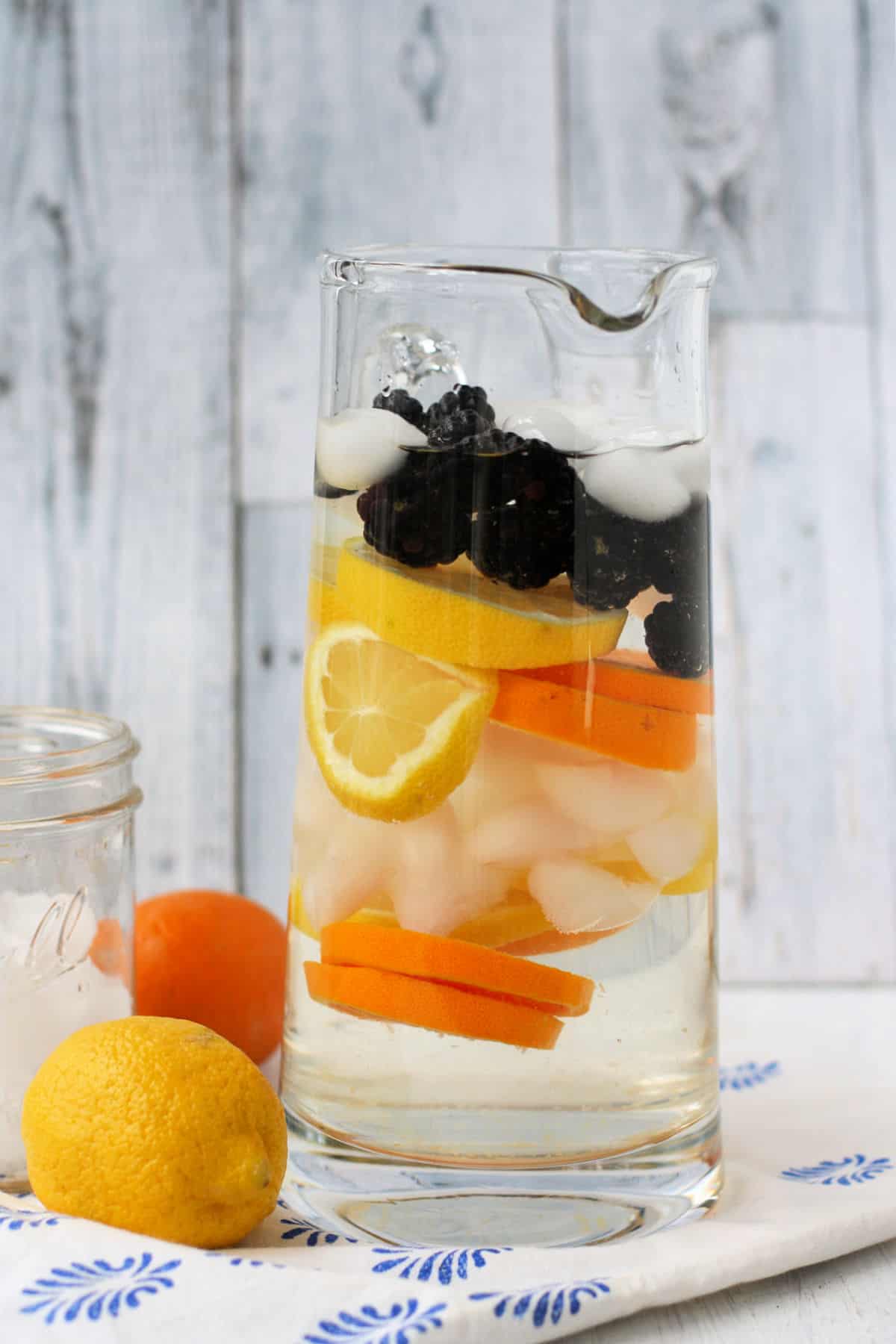 pitcher of water with blackberries and oranges