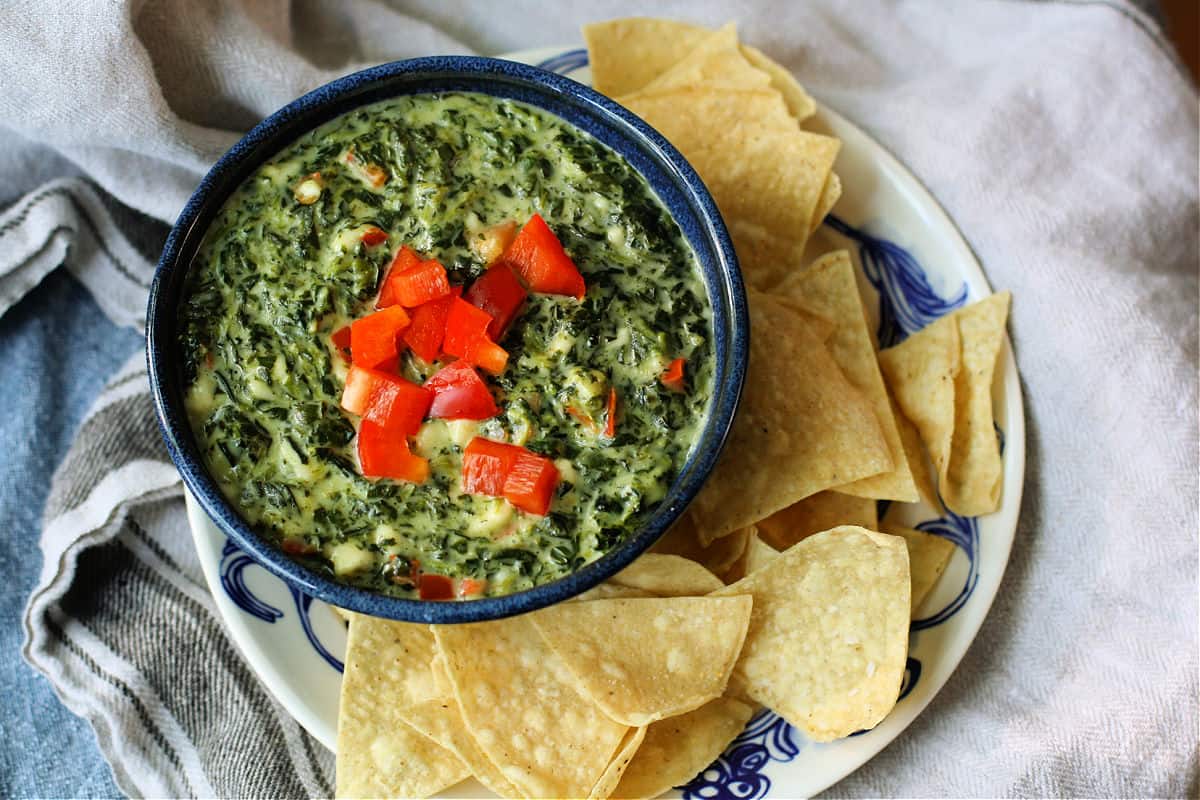 bowl of vegan spinach dip with corn chips