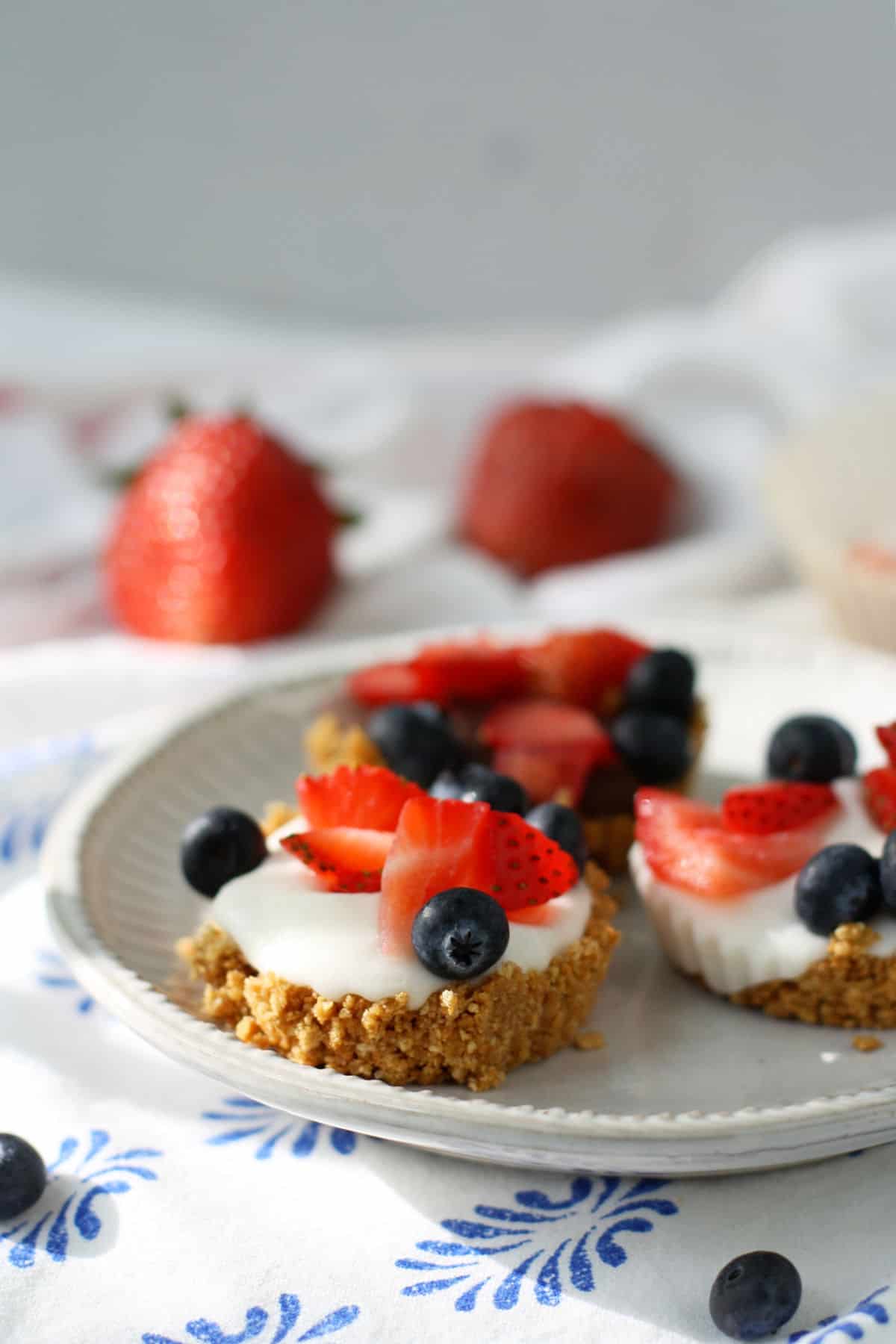 dairy free mini berry tarts on a white plate