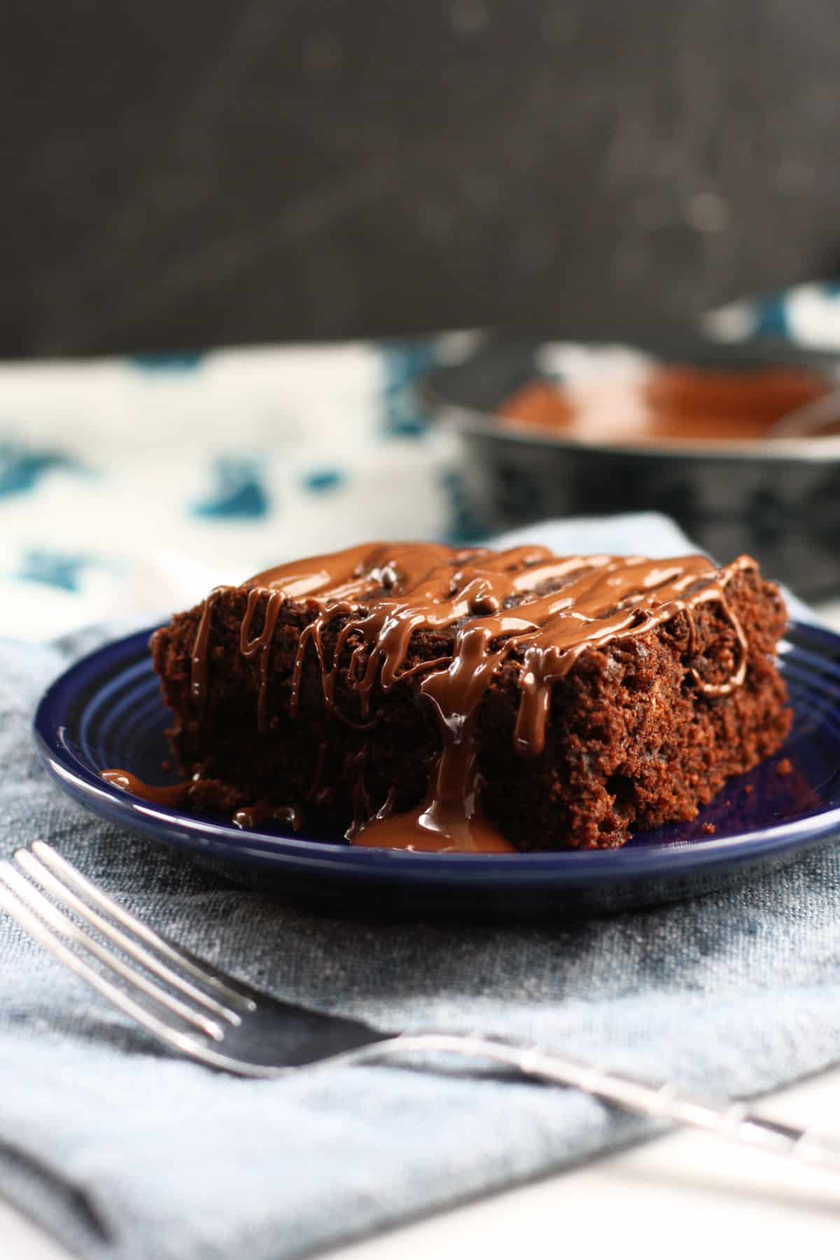 vegan chocolate cake with chocolate sauc on a blue plate