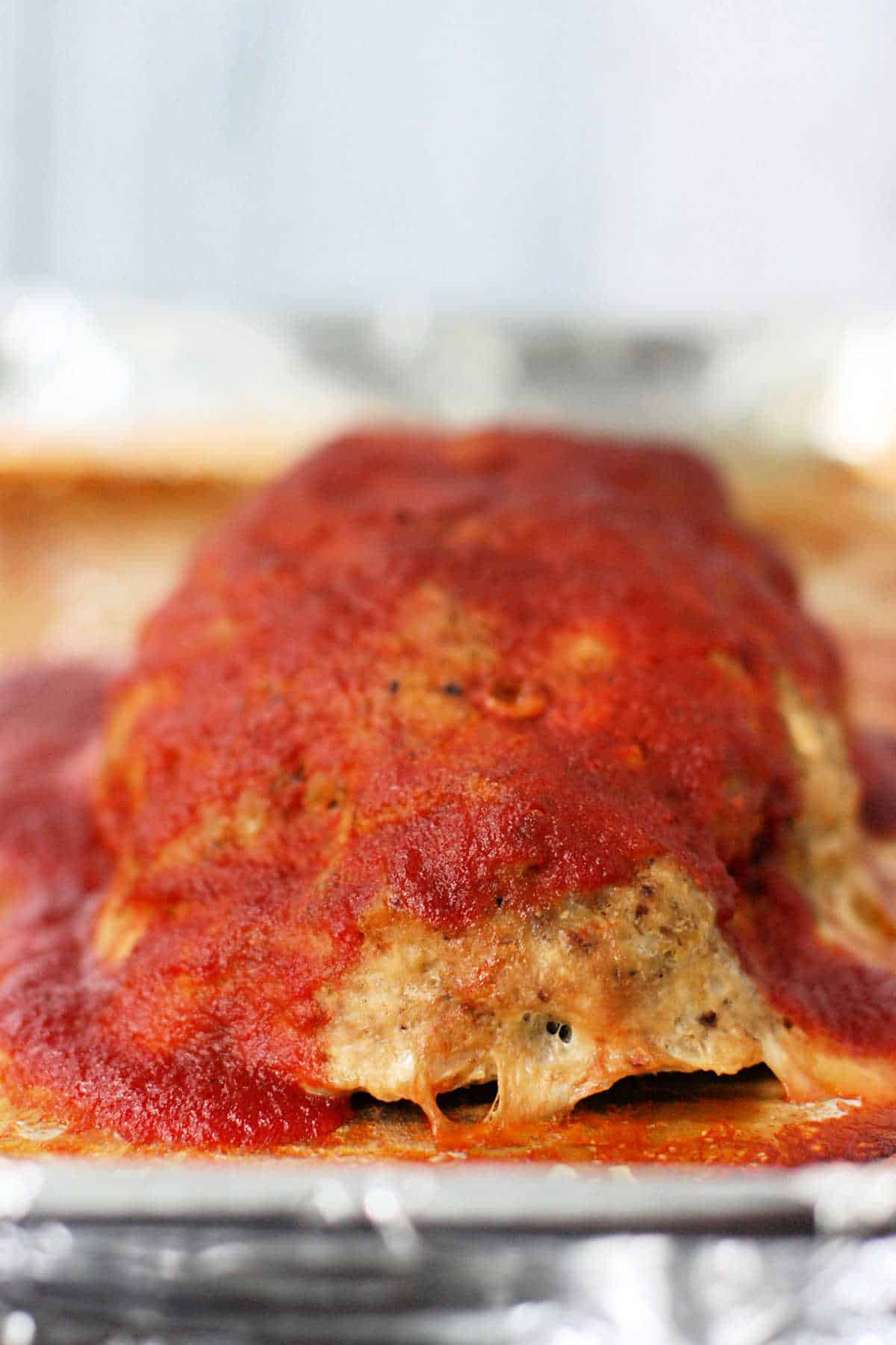 turkey meatloaf with tomato sauce on a baking sheet