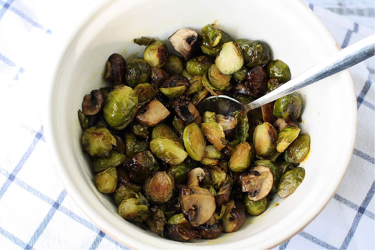roasted mushrooms and brussels sprouts with mustard in a bowl