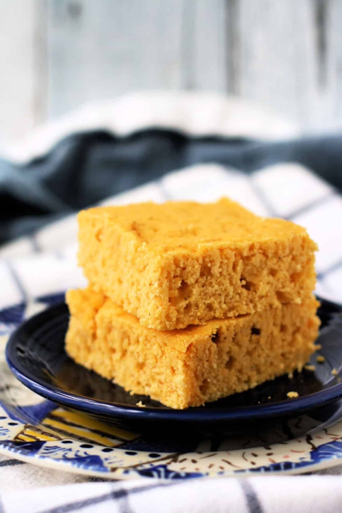 fluffy vegan cornbread stacked on a blue plate
