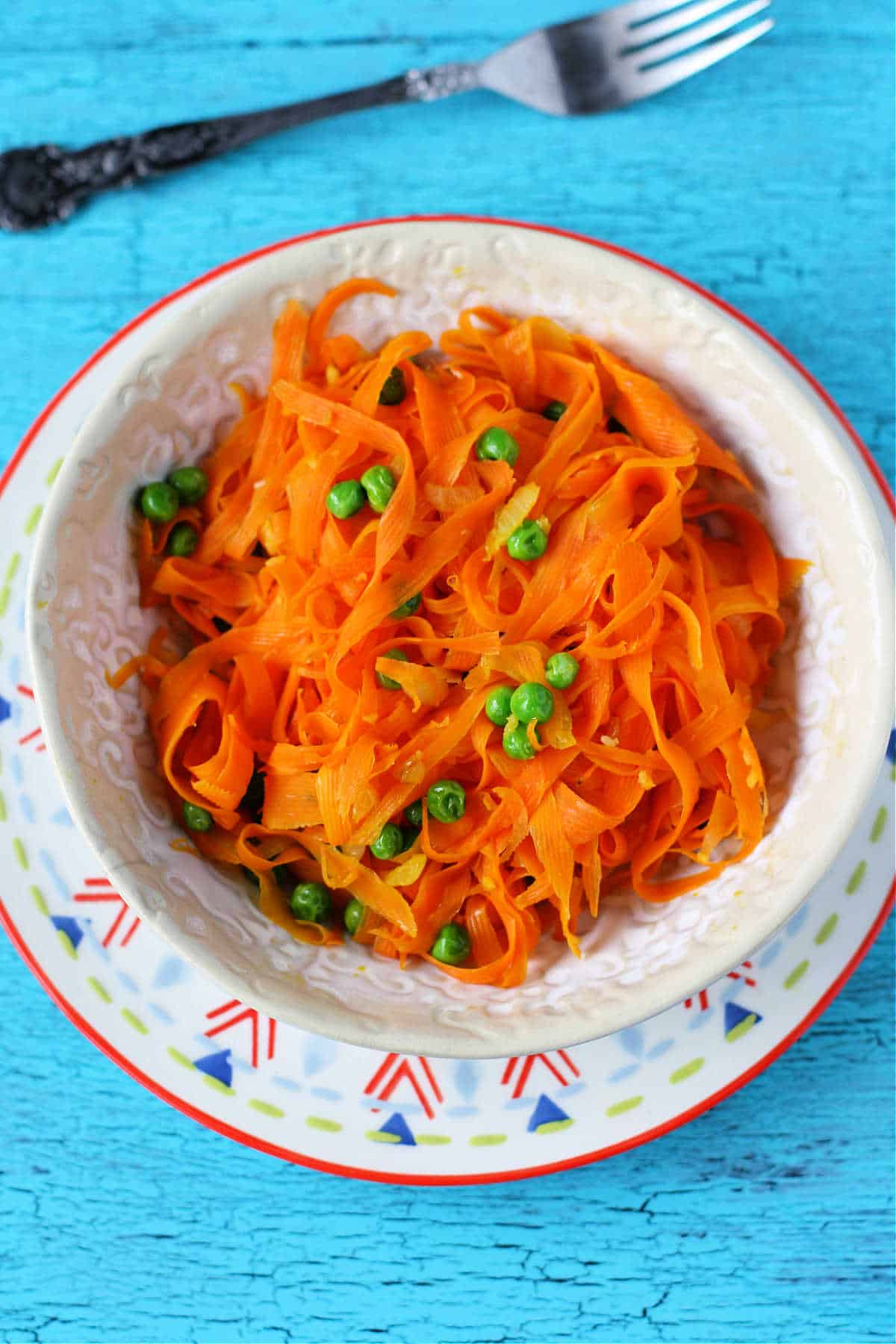 carrot noodles with peas in a bowl