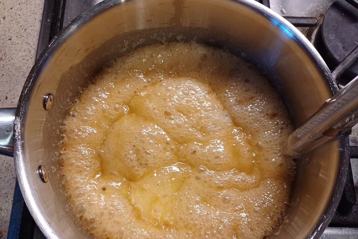 toffee in a pot with a candy thermometer