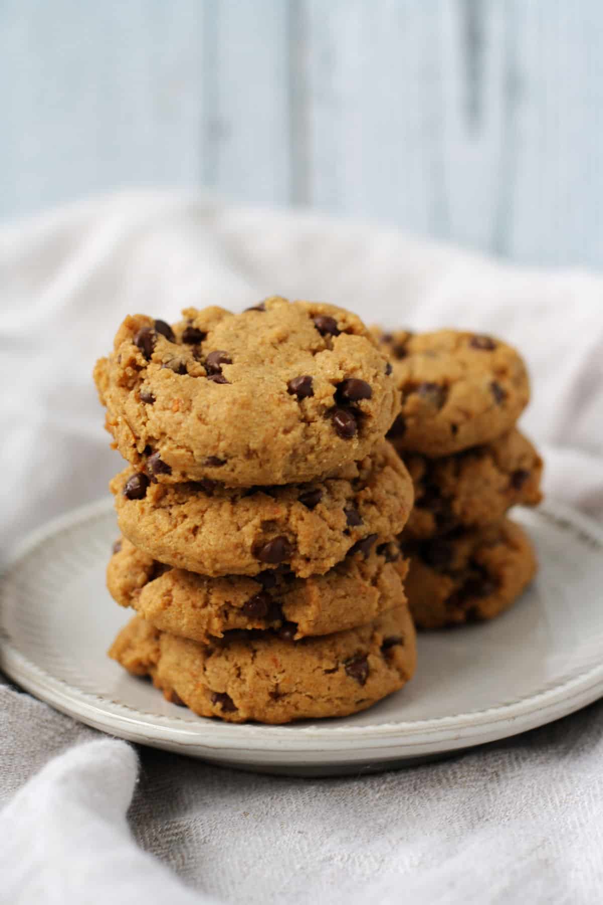 healthier chocolate chip cookies stacked on a white plate