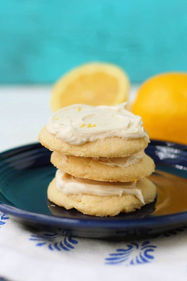 gluten free frosted lemon cookies stacked on a blue plate