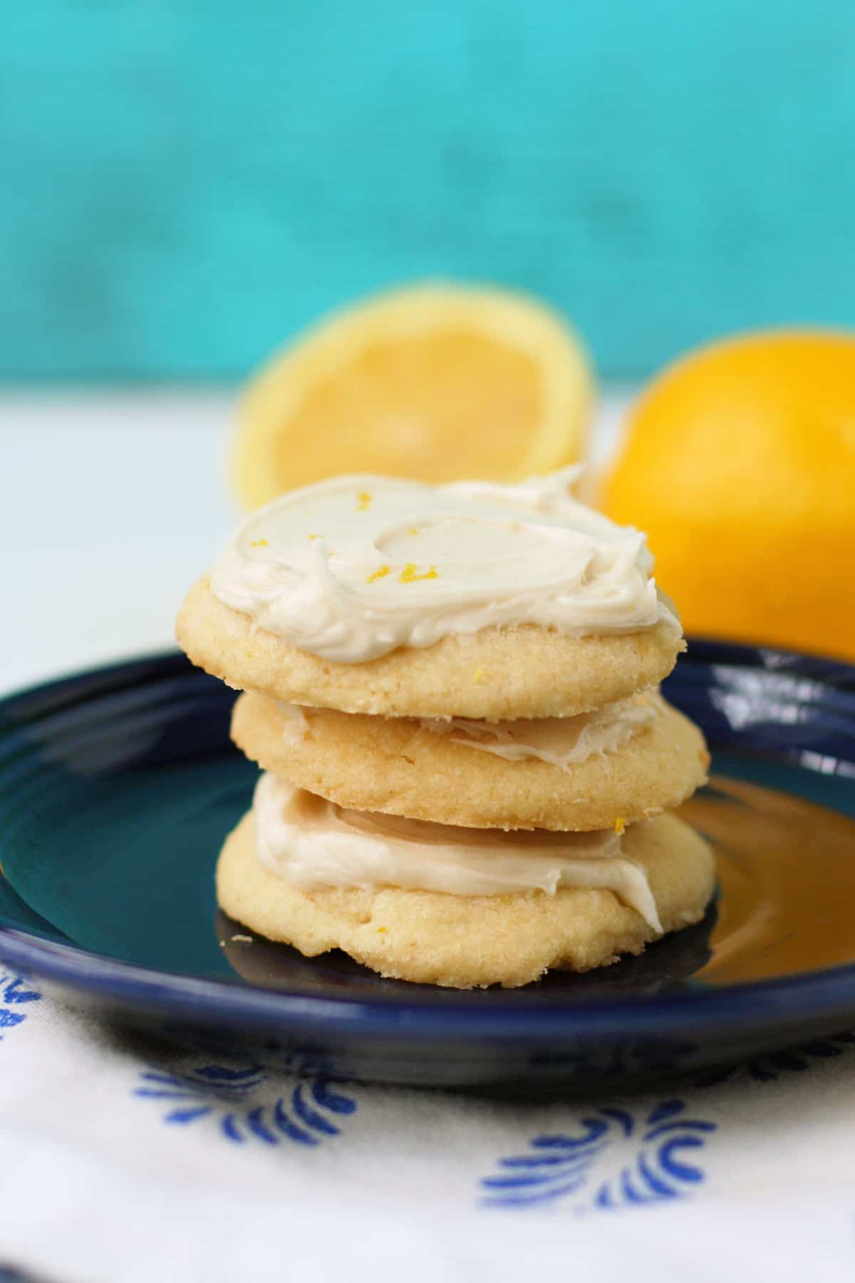 gluten free frosted lemon cookies stacked on a blue plate