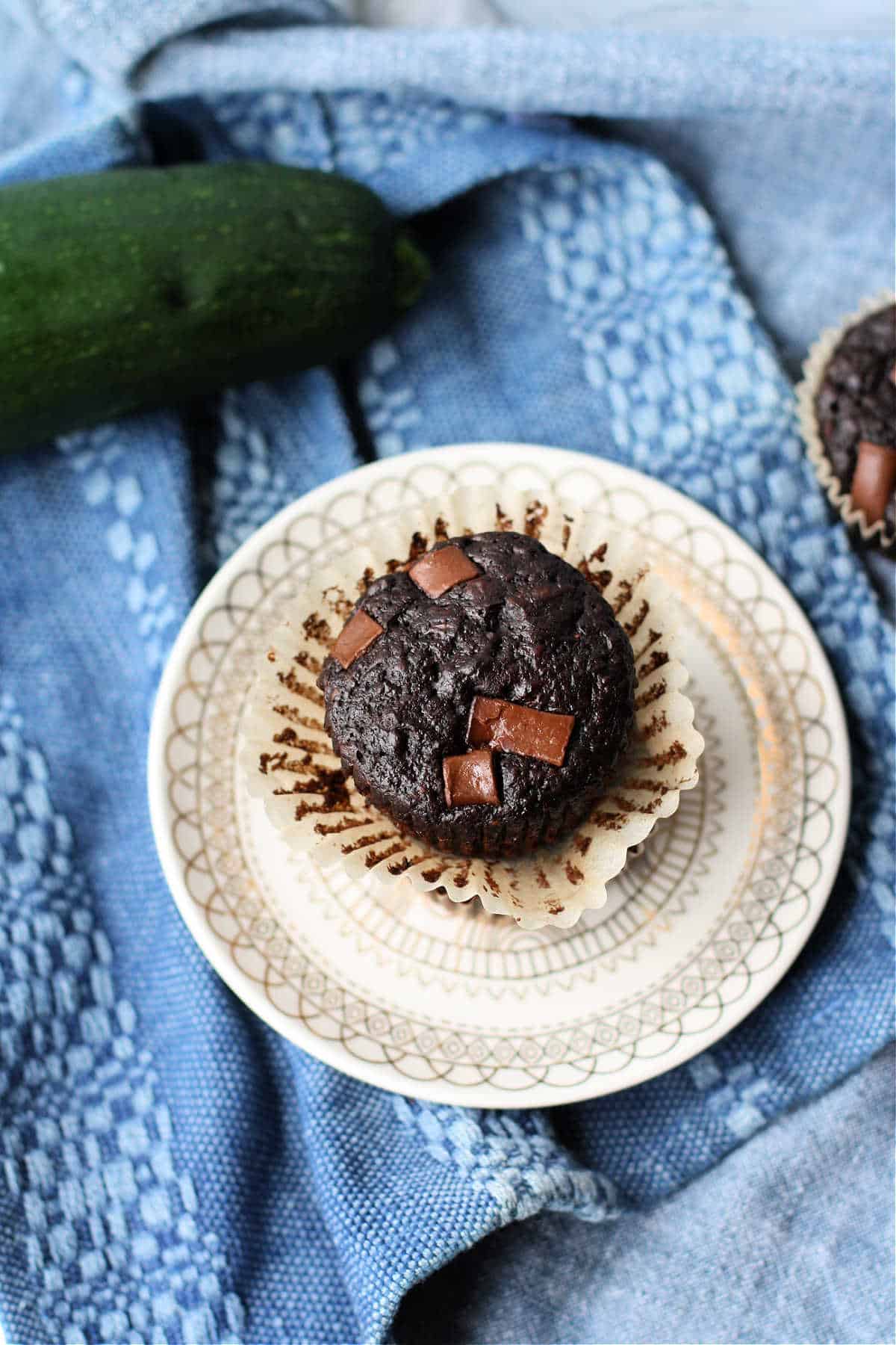 vegan chocolate zucchini muffin with chocolate chunks on a plate