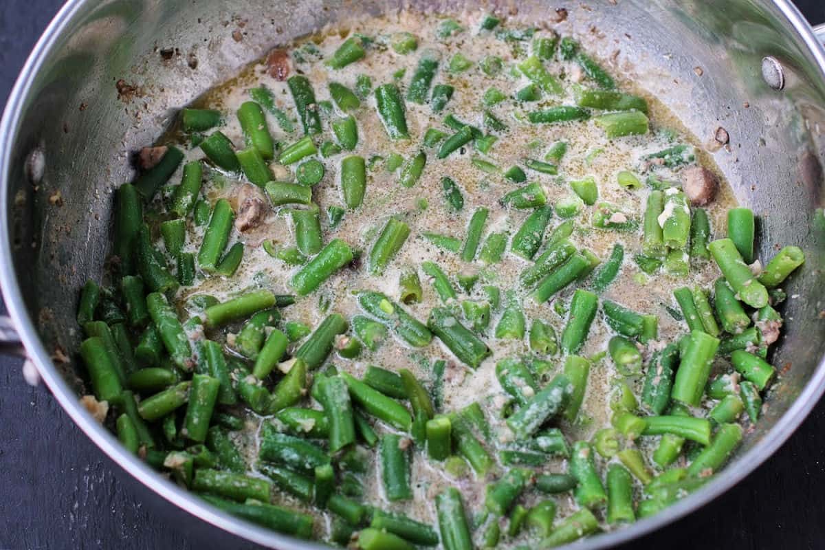 adding green beans to pan