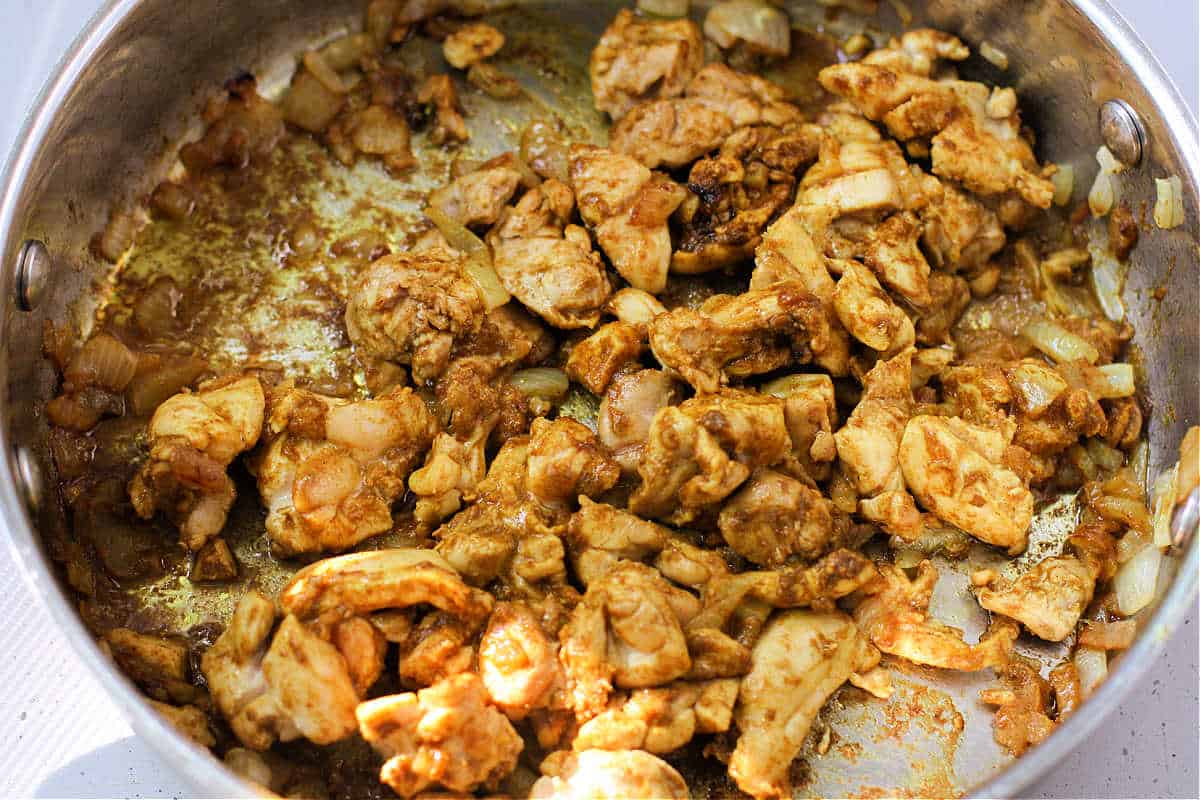 chicken cooking with curry spices