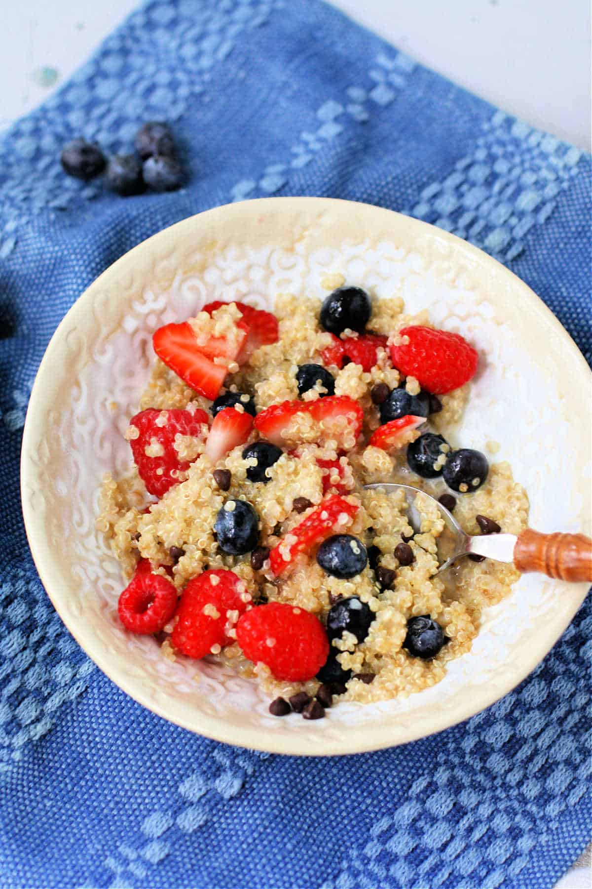 creamy quinoa porridge with fruit in a white bowl