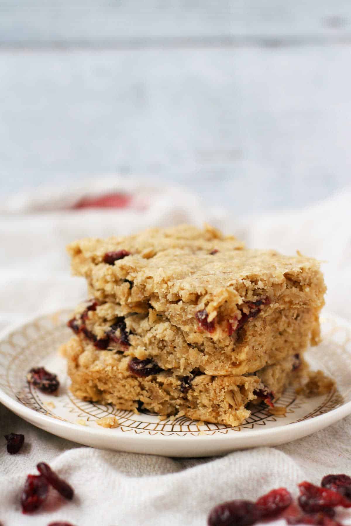 cranberry oat bars stacked on a plate