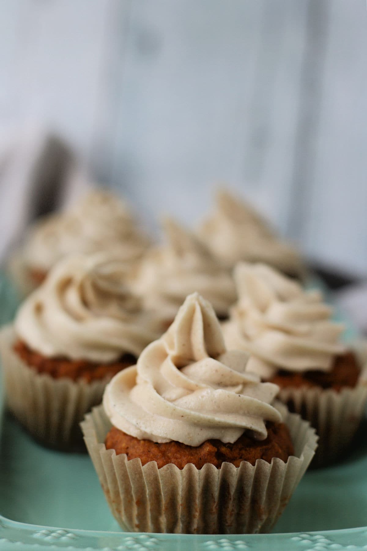 pumpkin cupcakes with dairy free buttercream frosting on a tray