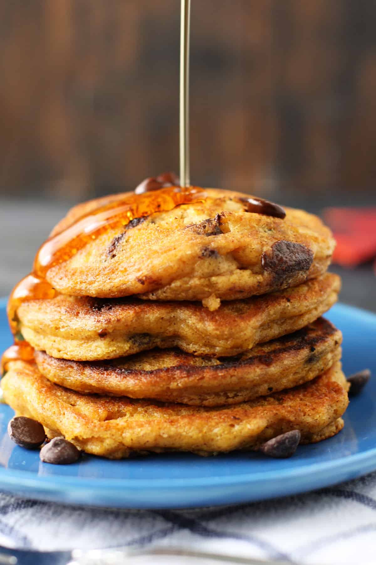 vegan pumpkin pancakes with chocolate chips on a blue plate