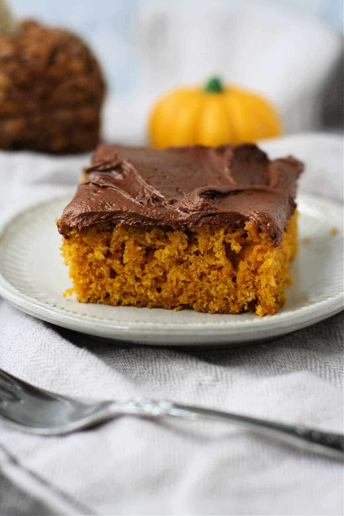 slice of pumpkin sheet cake with chocolate frosting