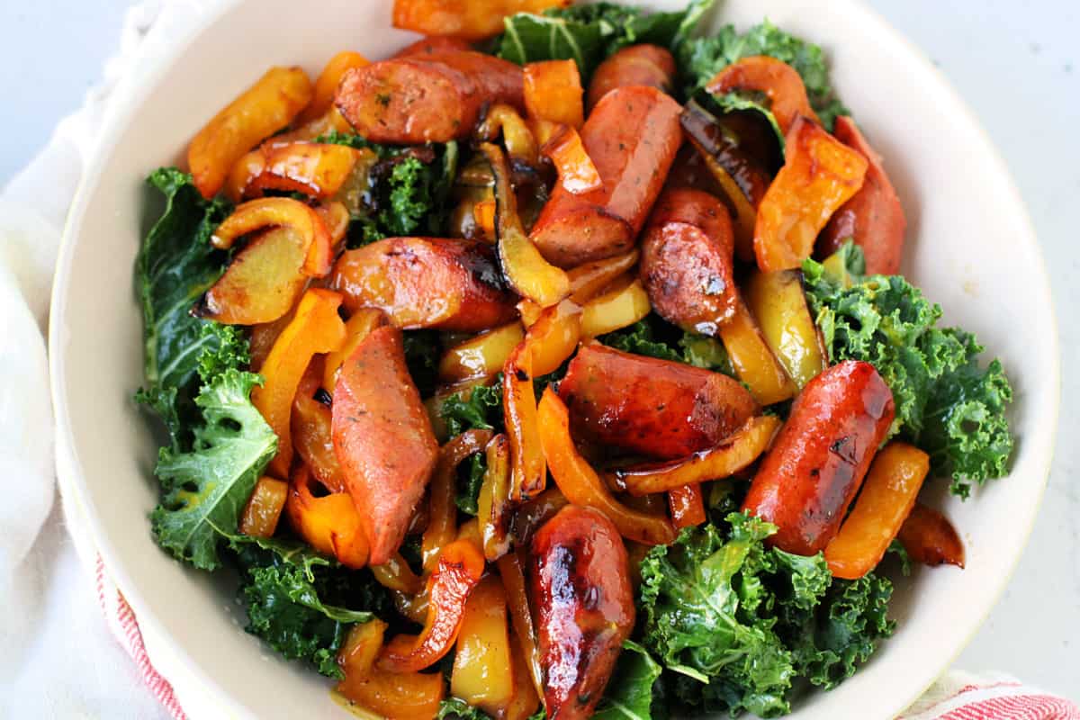 sausages and peppers over kale salad