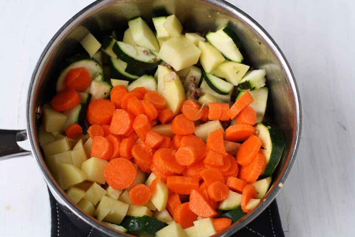 adding carrots zucchini and potatoes