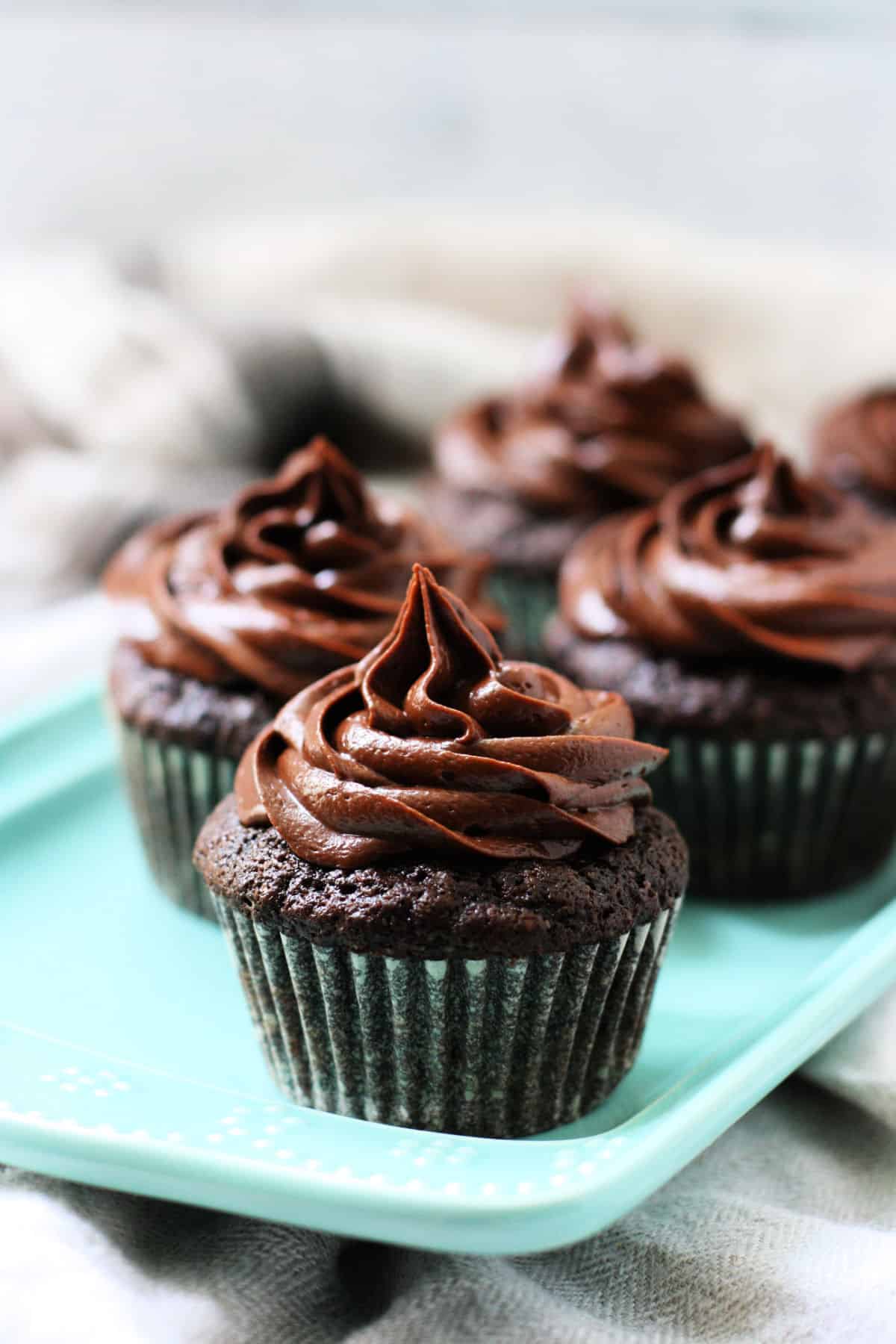 the best gluten free vegan chocolate cupcakes on a teal ceramic tray