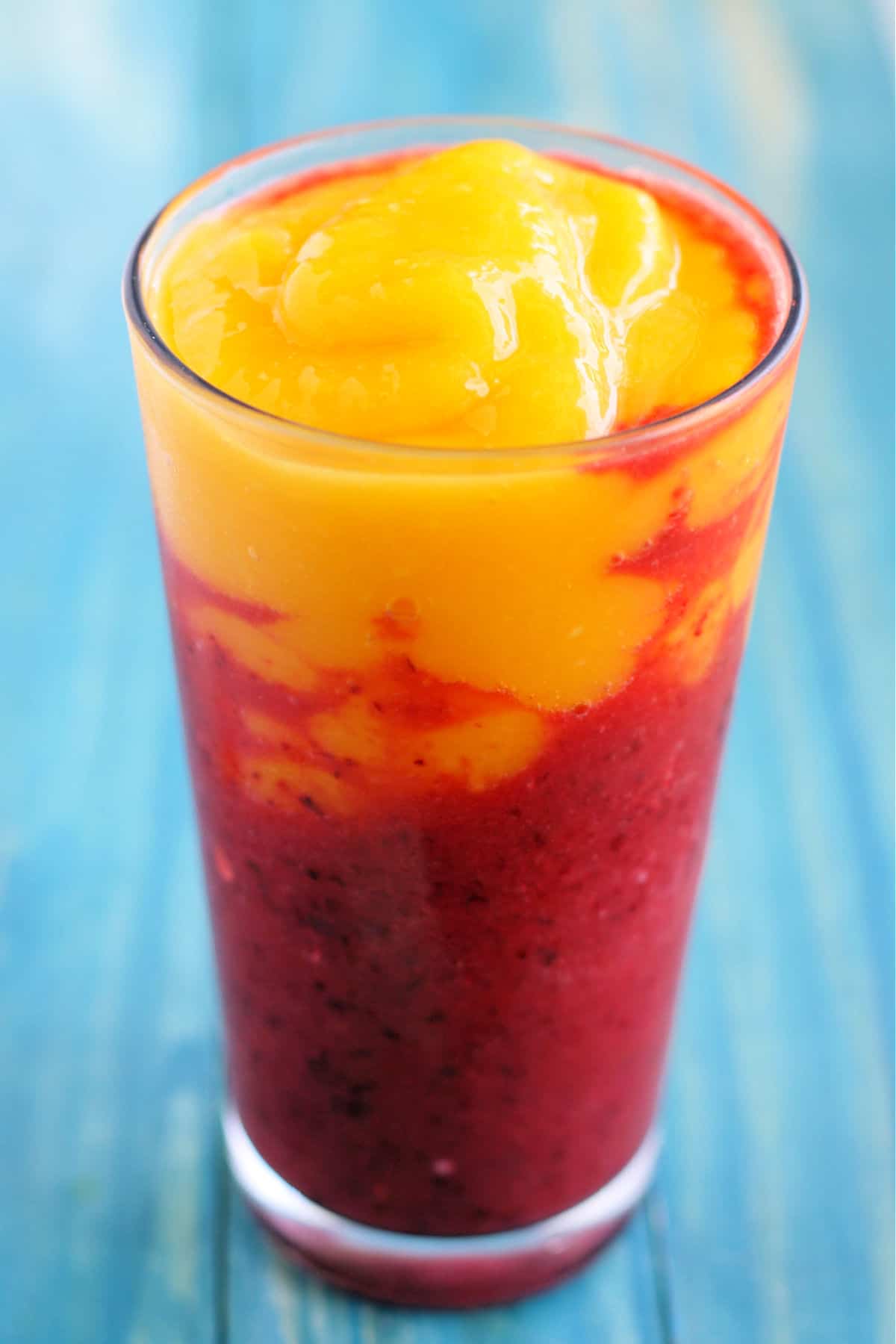cherry mango smoothie on a blue table