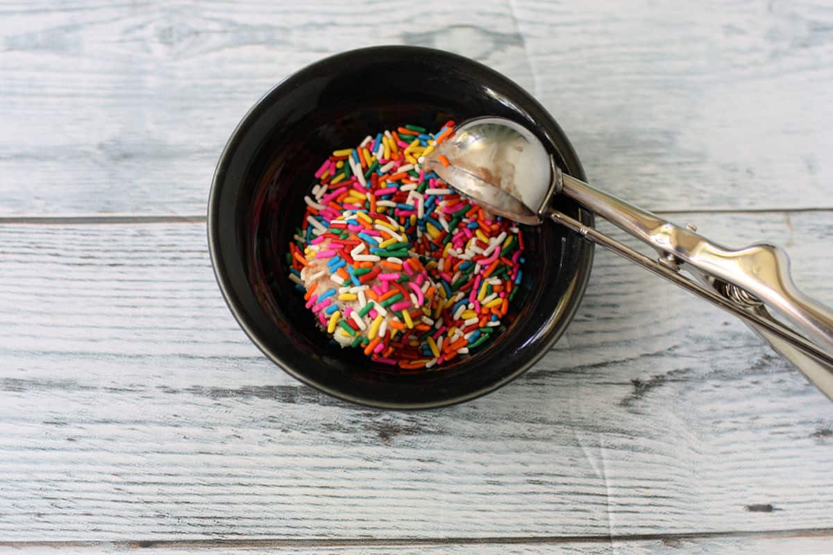 dipping ice cream balls in sprinkles