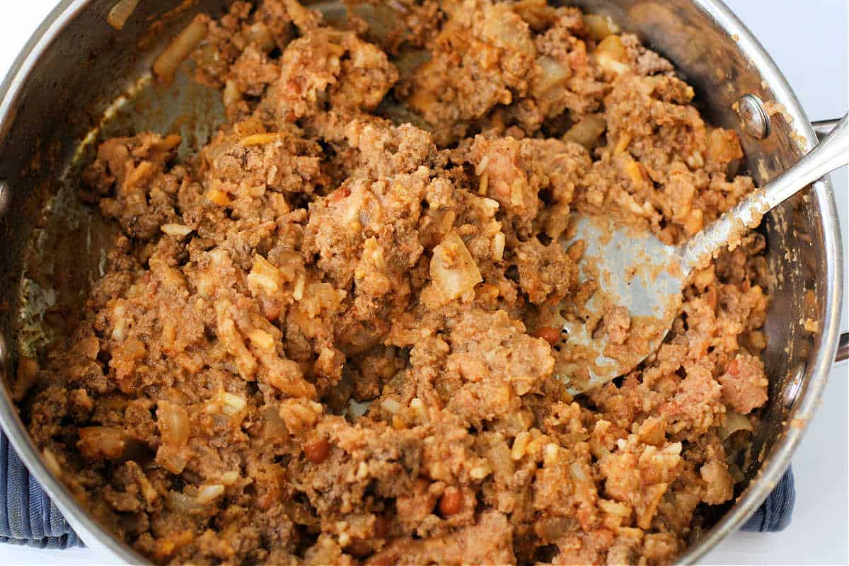 adding the dairy free beans and cheese to the beef