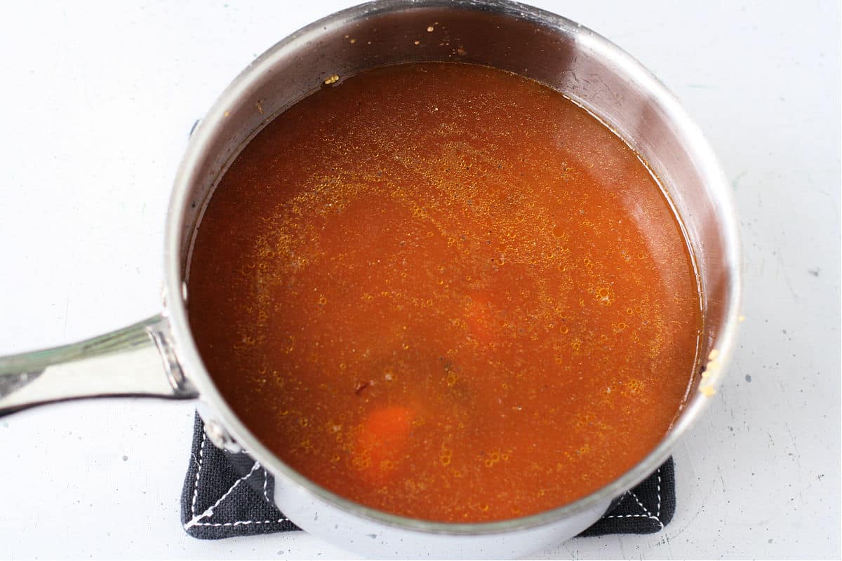 adding the broth to the pan