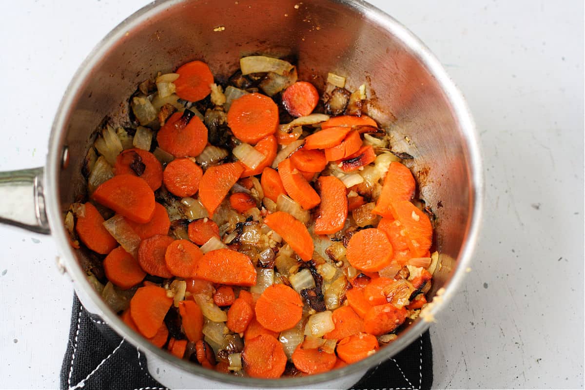 cooking carrots and onions in pan