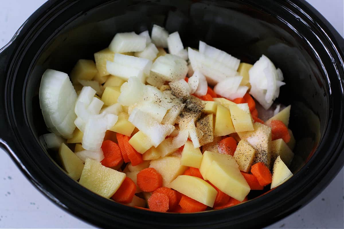 adding the vegetables to the slow cooker