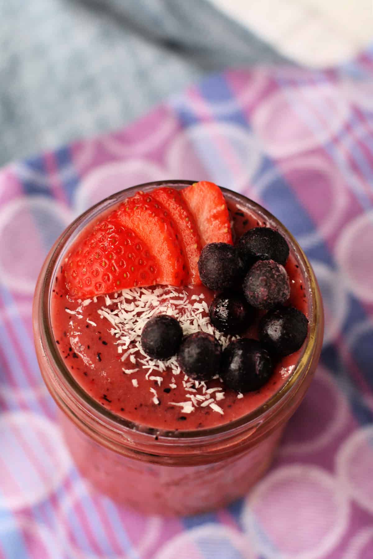 berry smoothie in a mason jar topped with berries