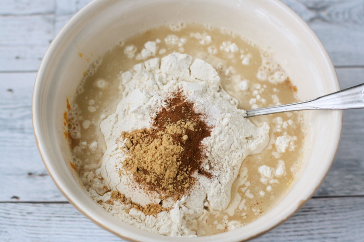 adding dry ingredients to the pumpkin batter