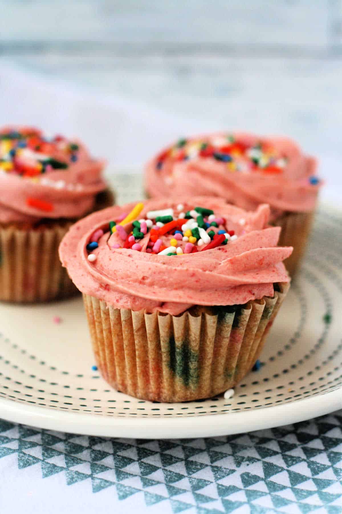vegan funfetti cupcakes with pink frosting on a white plate