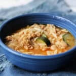 sausage orzo zucchini soup in a blue ceramic bowl